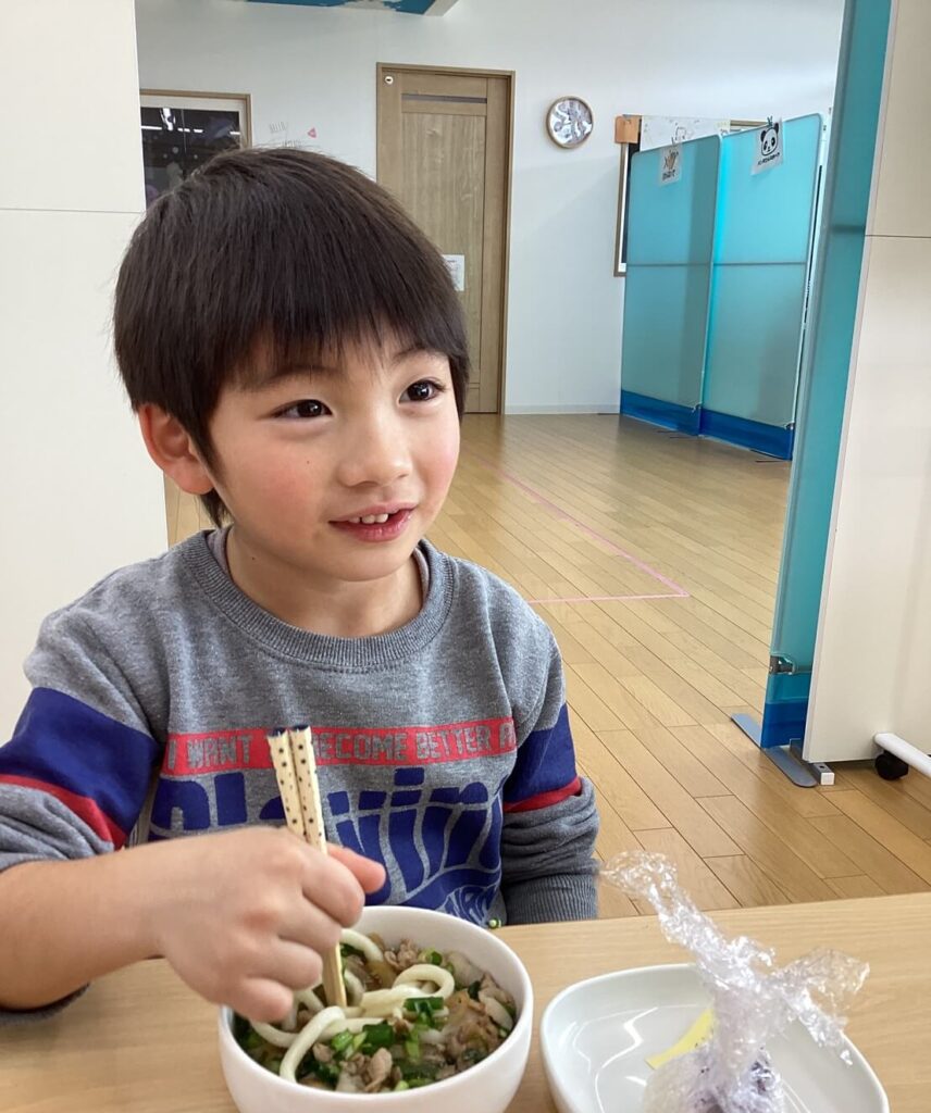 小さな男の子がご飯を食べている